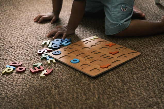 Child playing with alphabet puzzle on carpet