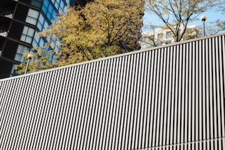 Black metal slat privacy fence by Young Bros