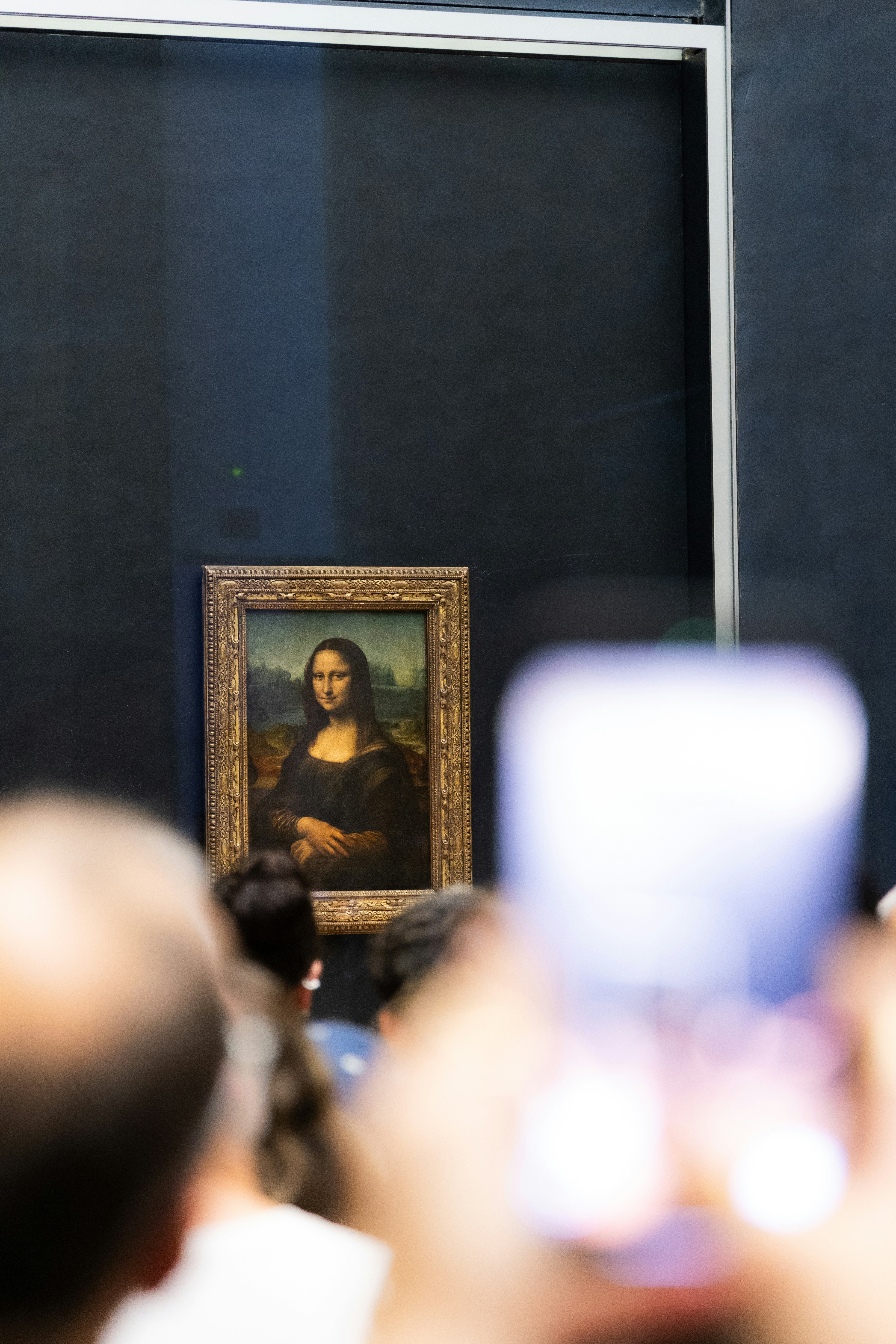 Mona Lisa painting behind glass with crowd