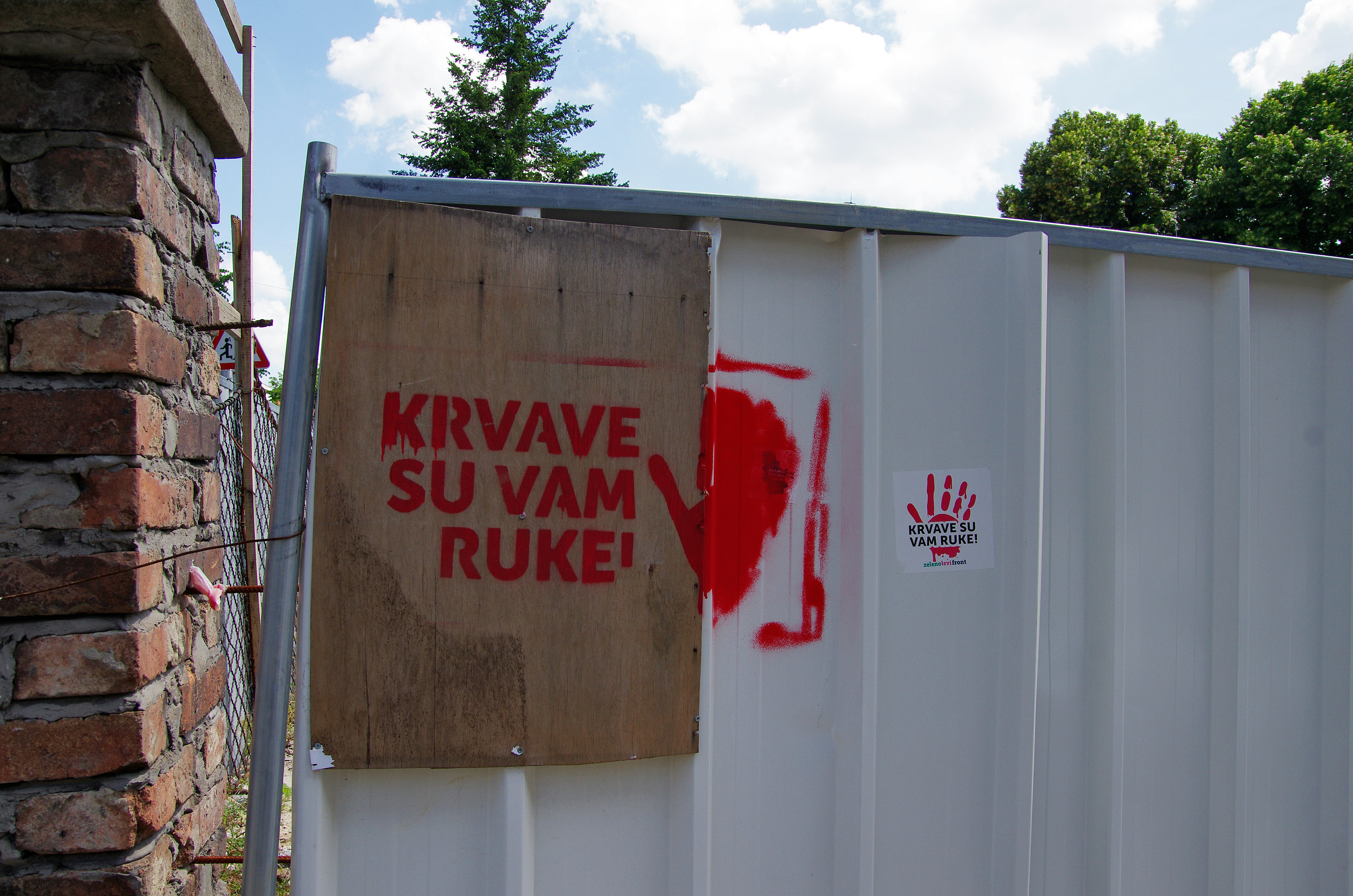 Red handprint and text on a fence