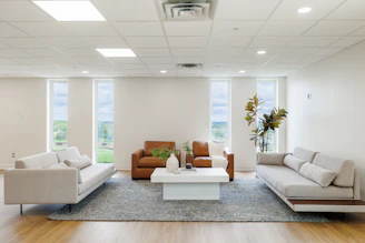 Modern living room with three sofas and coffee table.