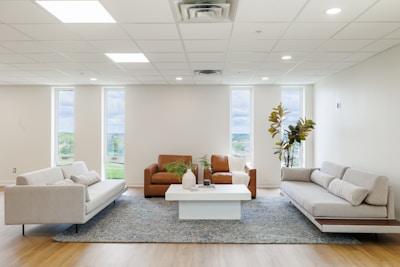 Modern living room with three sofas and coffee table.