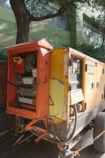 Yellow industrial generator with open electrical panel