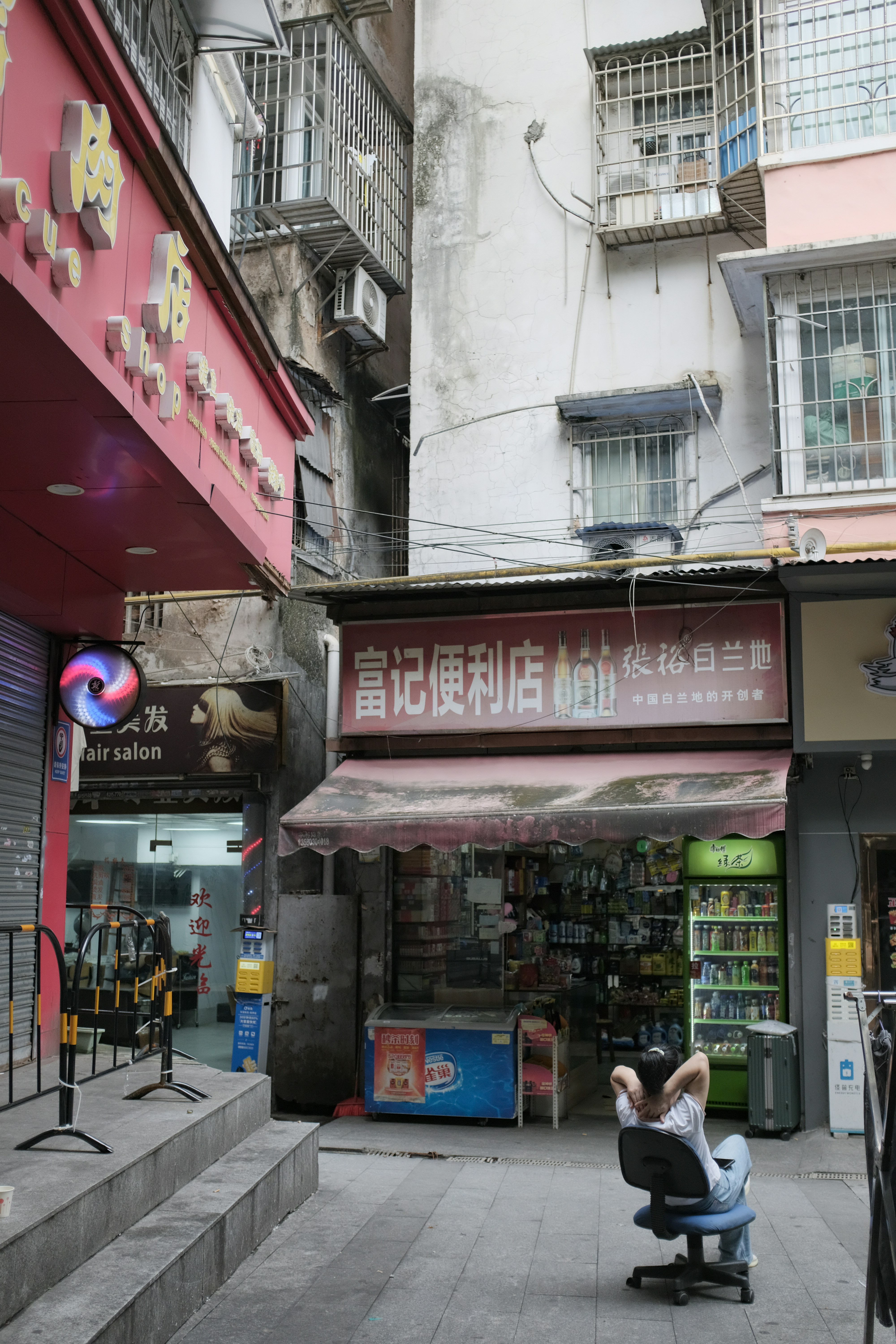 Uomo che si rilassa all'esterno di un piccolo minimarket.