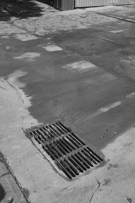 Metal grate on wet concrete pavement