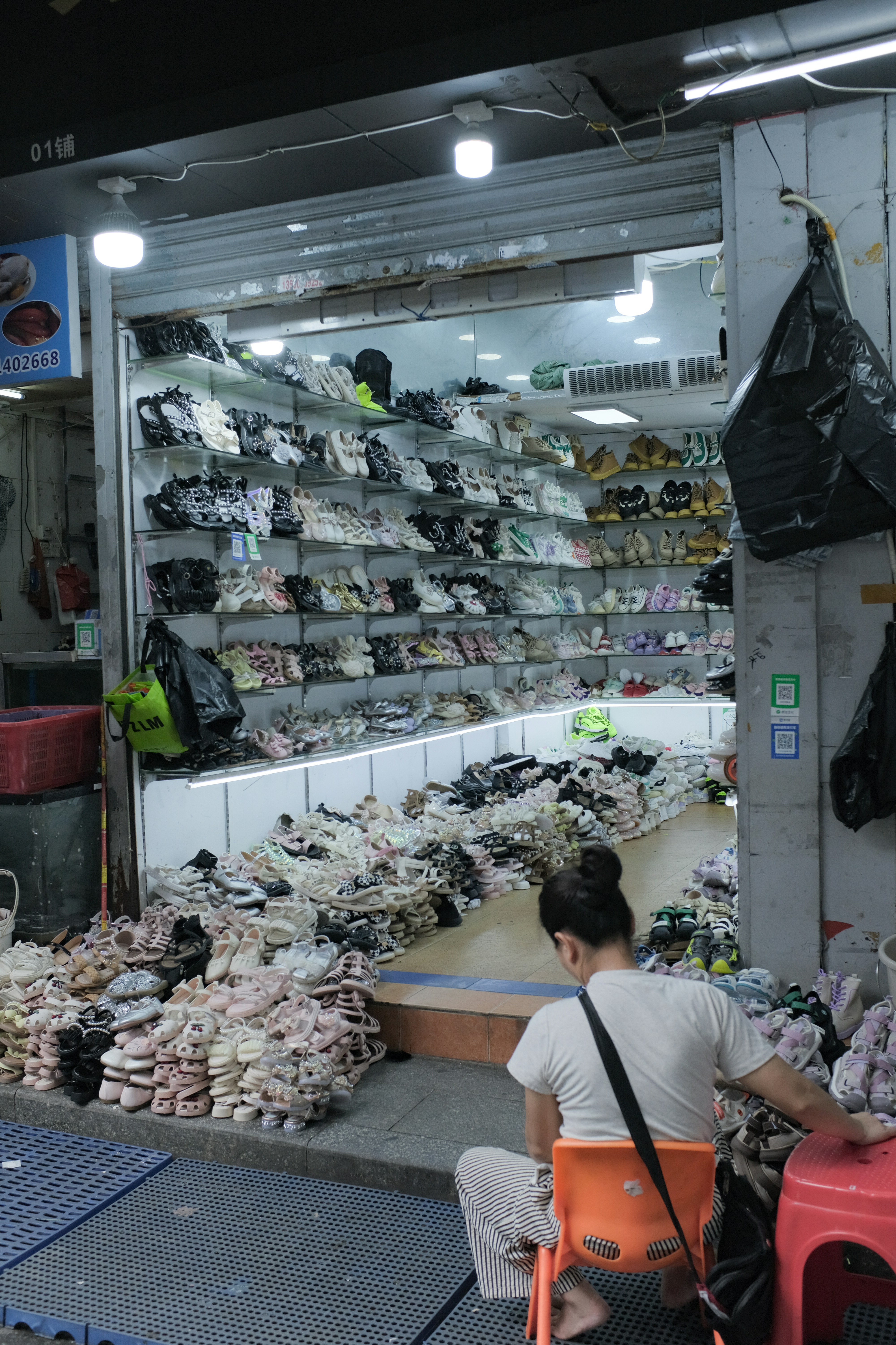 Shoe store with many sandals and sneakers displayed.