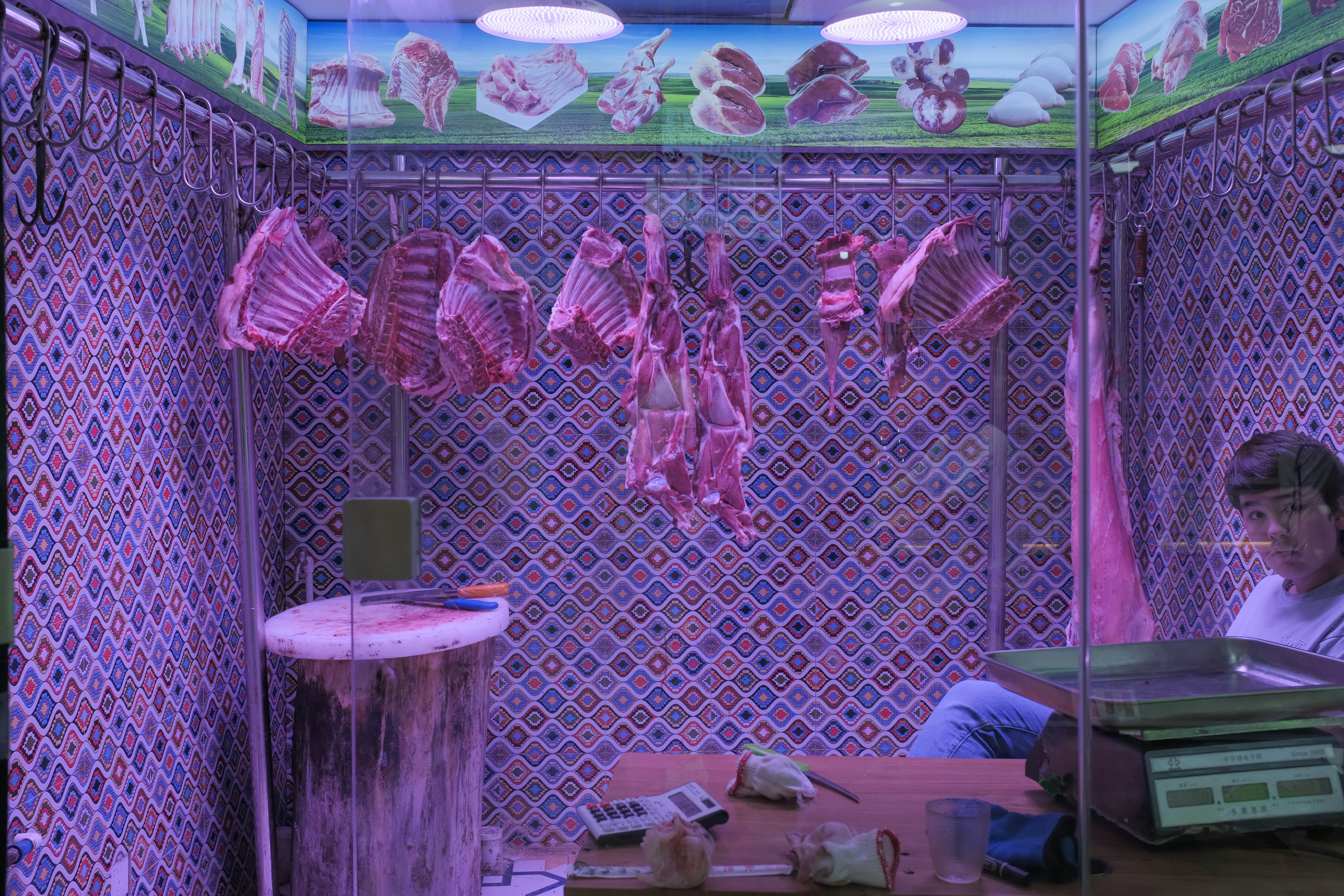 Butcher shop with hanging meats and a person