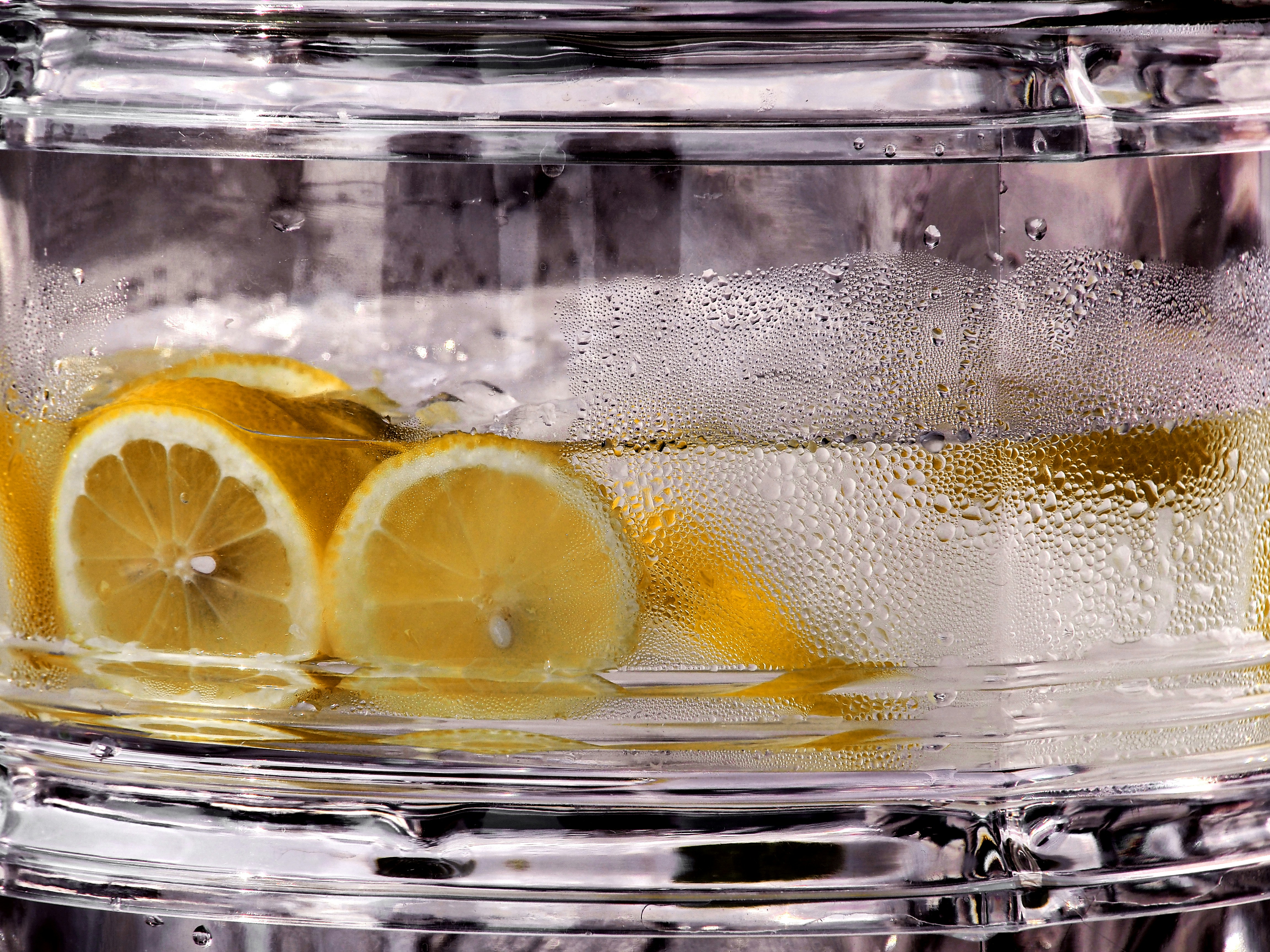 Lemon slices floating in clear liquid with condensation.