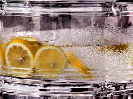 Lemon slices floating in clear liquid with condensation.