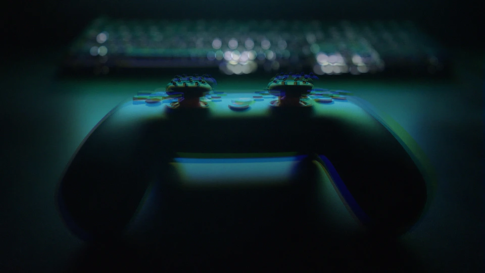 Close-up view of a black and white videogame controller on a dark surface