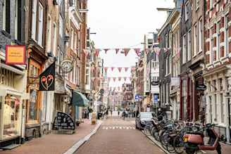 Narrow street lined with shops and parked bicycles.