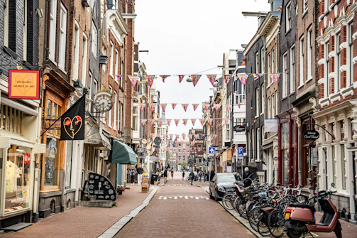 Narrow street lined with shops and parked bicycles.