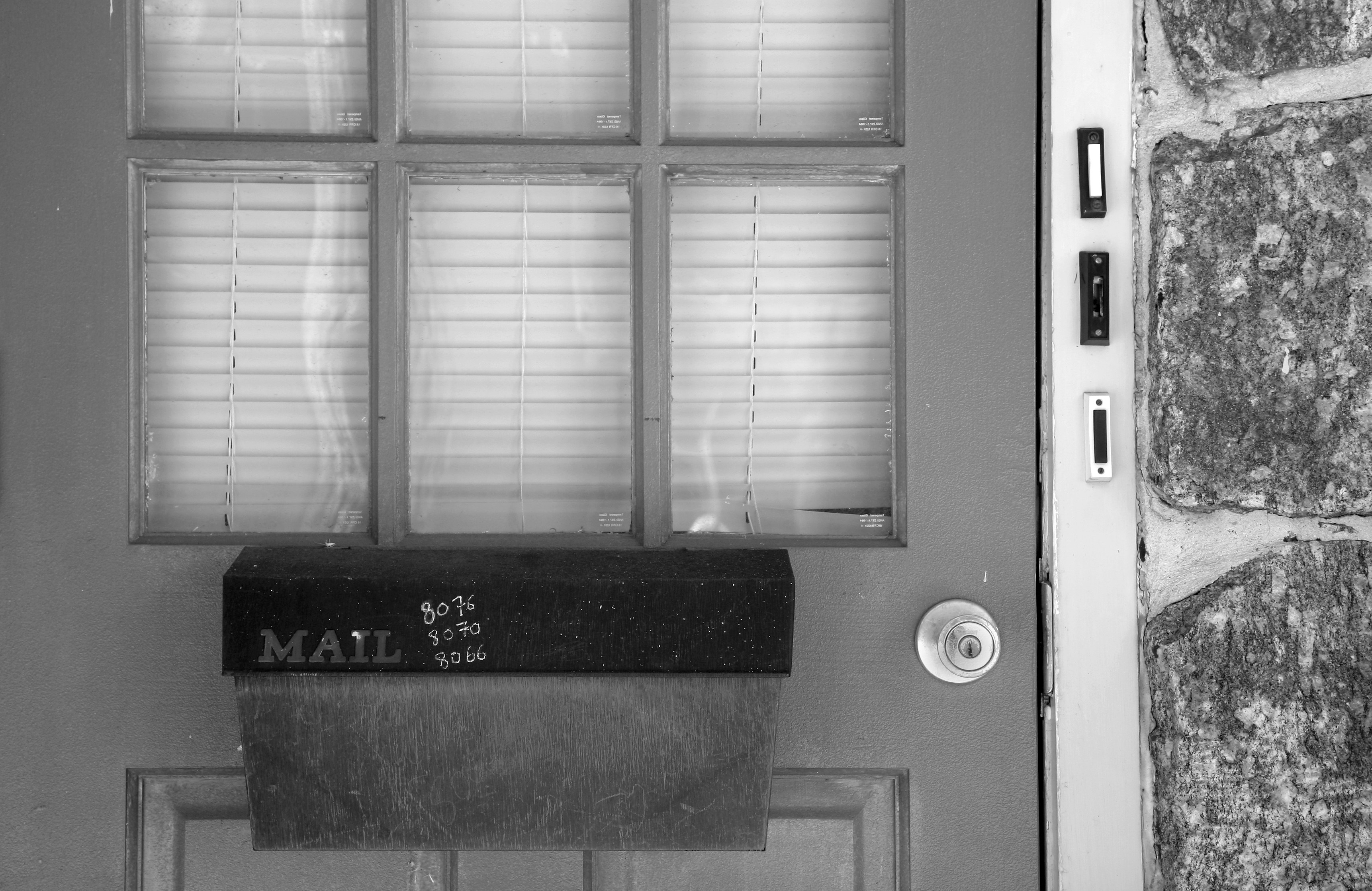 Cassetta delle lettere attaccata a una porta con vetri.