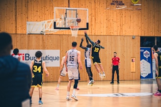 Basketball players jump for a rebound during a game.