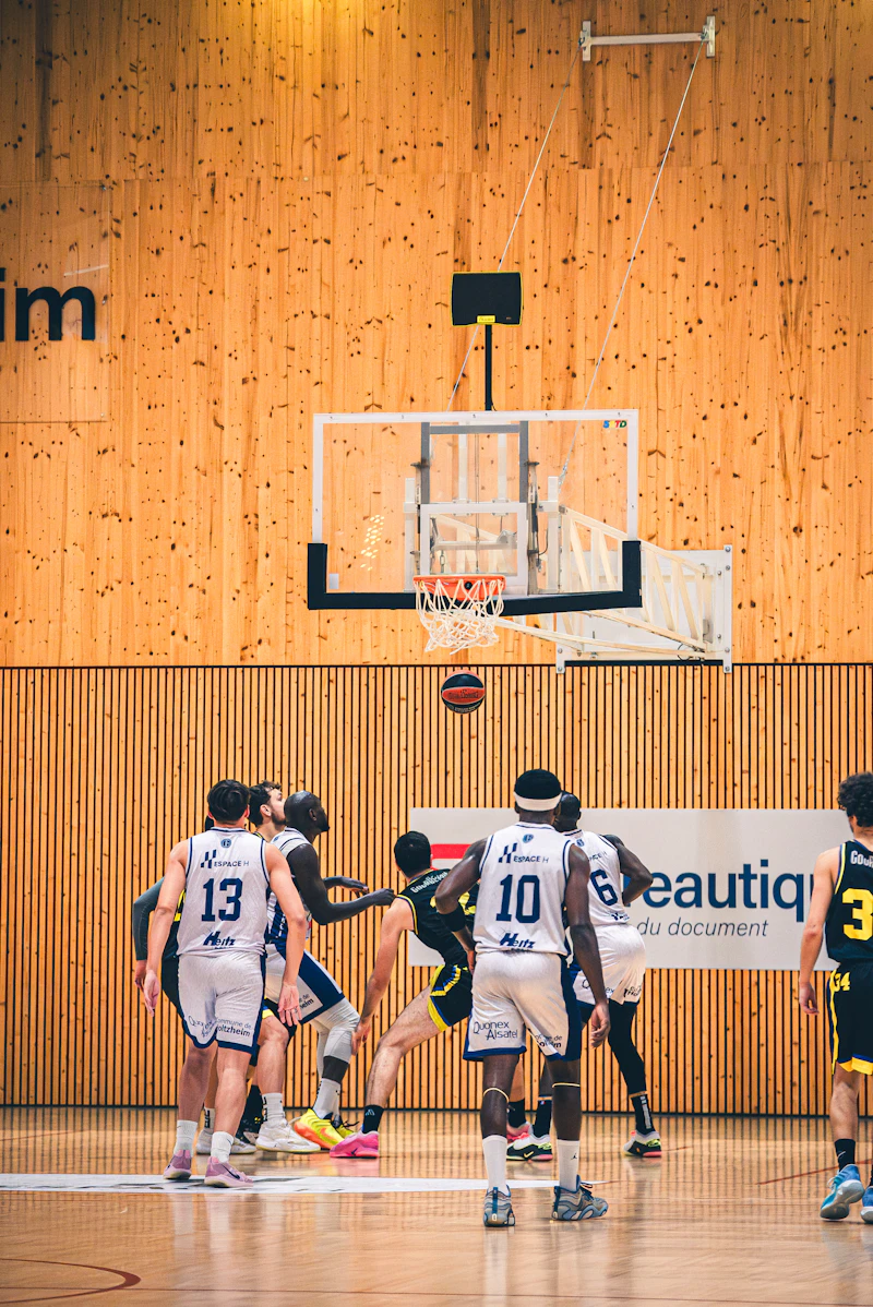 Basketball players competing under the hoop during a game