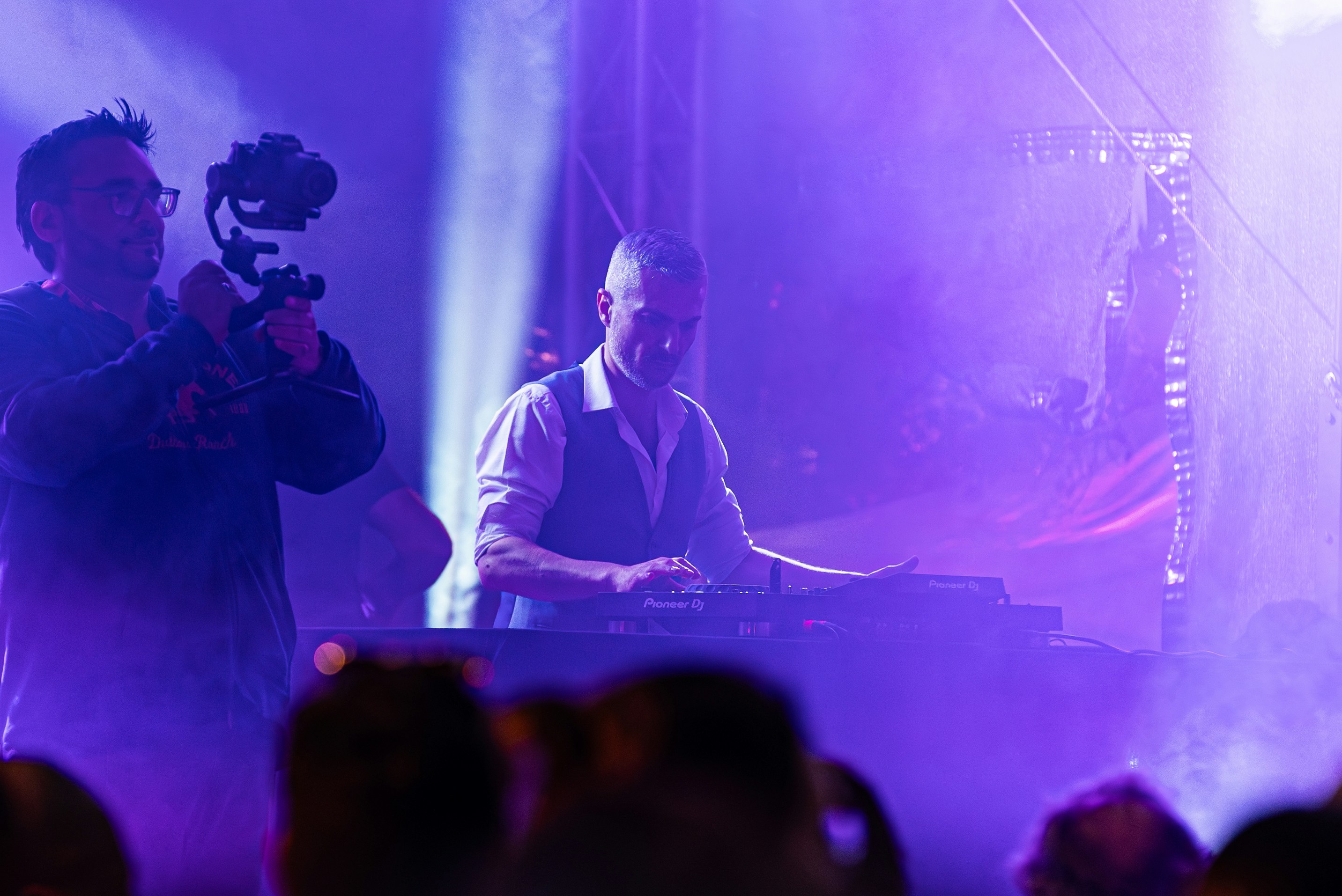 Dj performing on stage with purple lighting