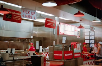 Employees working behind counter in fast food restaurant.