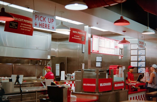 Employees working behind counter in fast food restaurant.