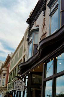Historic buildings with string lights and ice cream shop sign