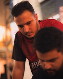 Two men looking down intently at something.