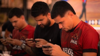 Three men looking down at their phones