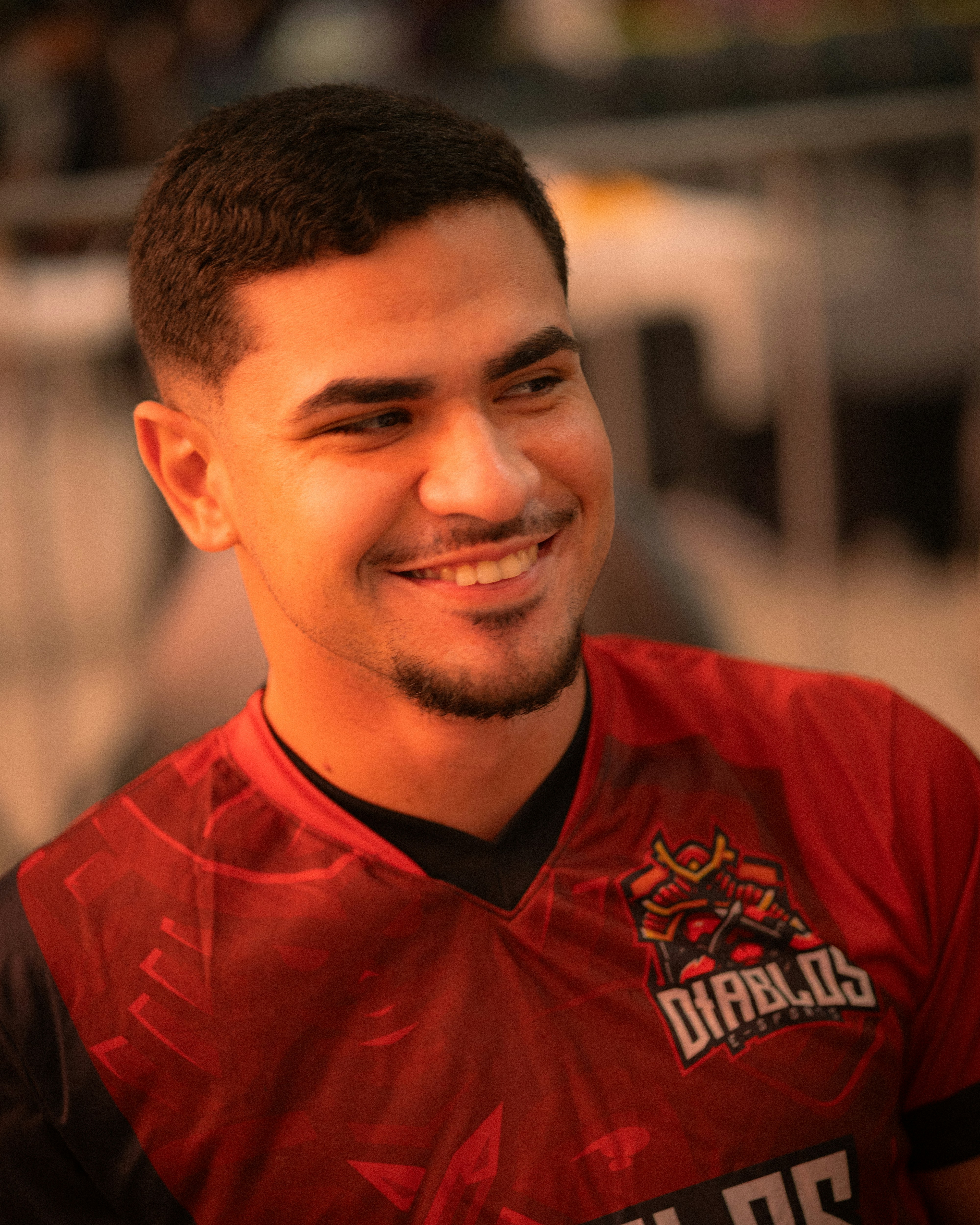 Young man smiling, wearing a red jersey.