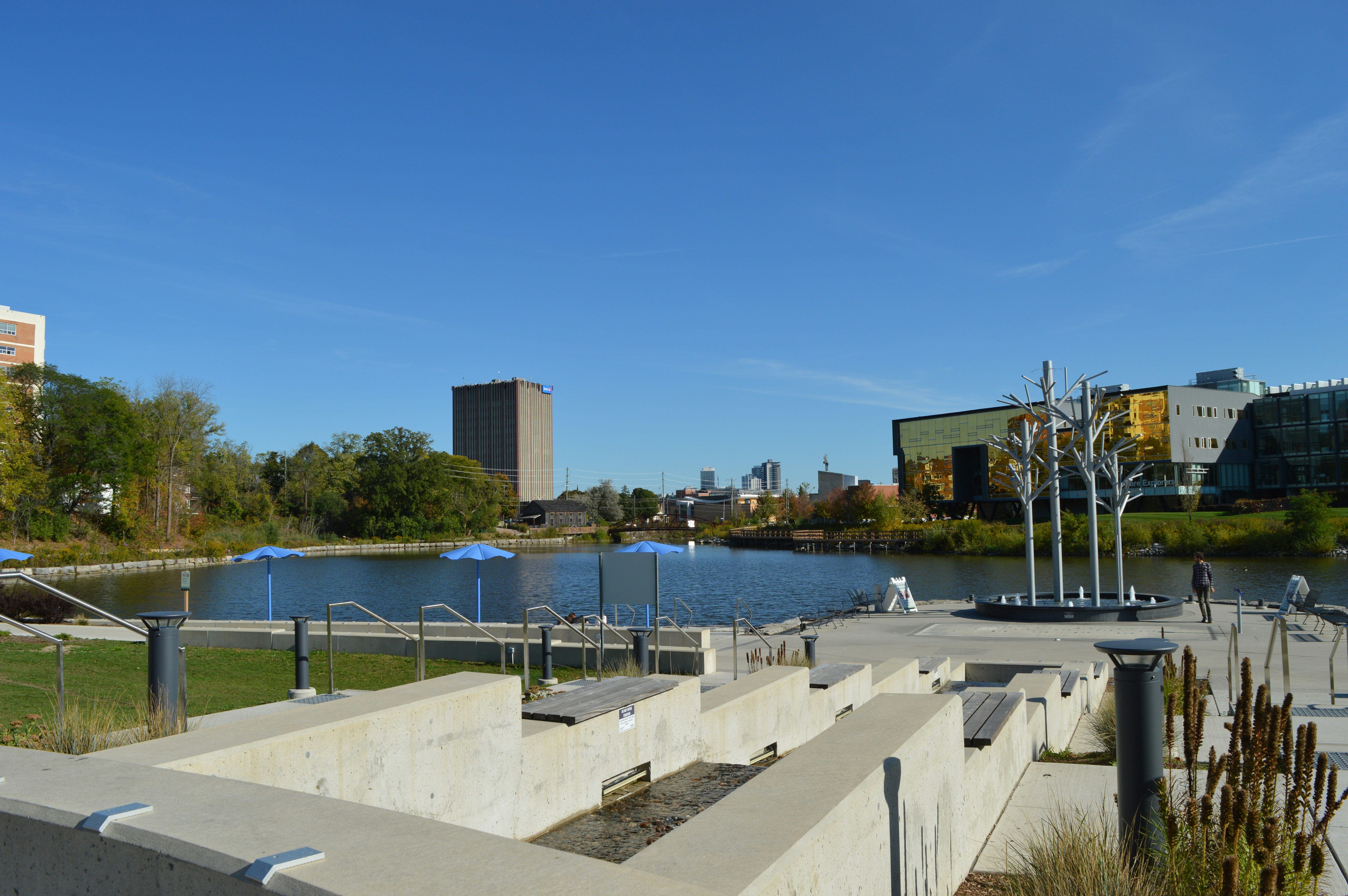 Modern buildings surrounding a tranquil lake on a clear day