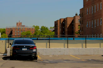 Black car parked in a sunny parking lot.