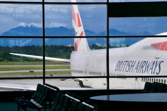 British airways airplane parked at airport with mountains behind