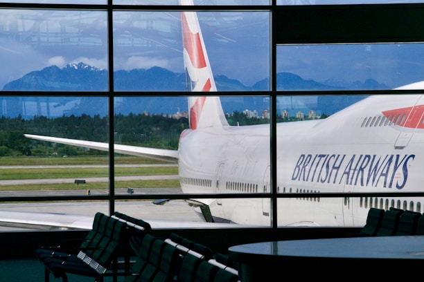 British airways airplane parked at airport with mountains behind