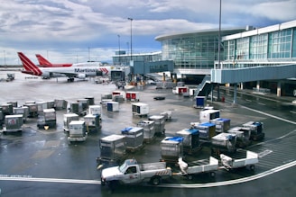 Airport tarmac with luggage carts and airplane