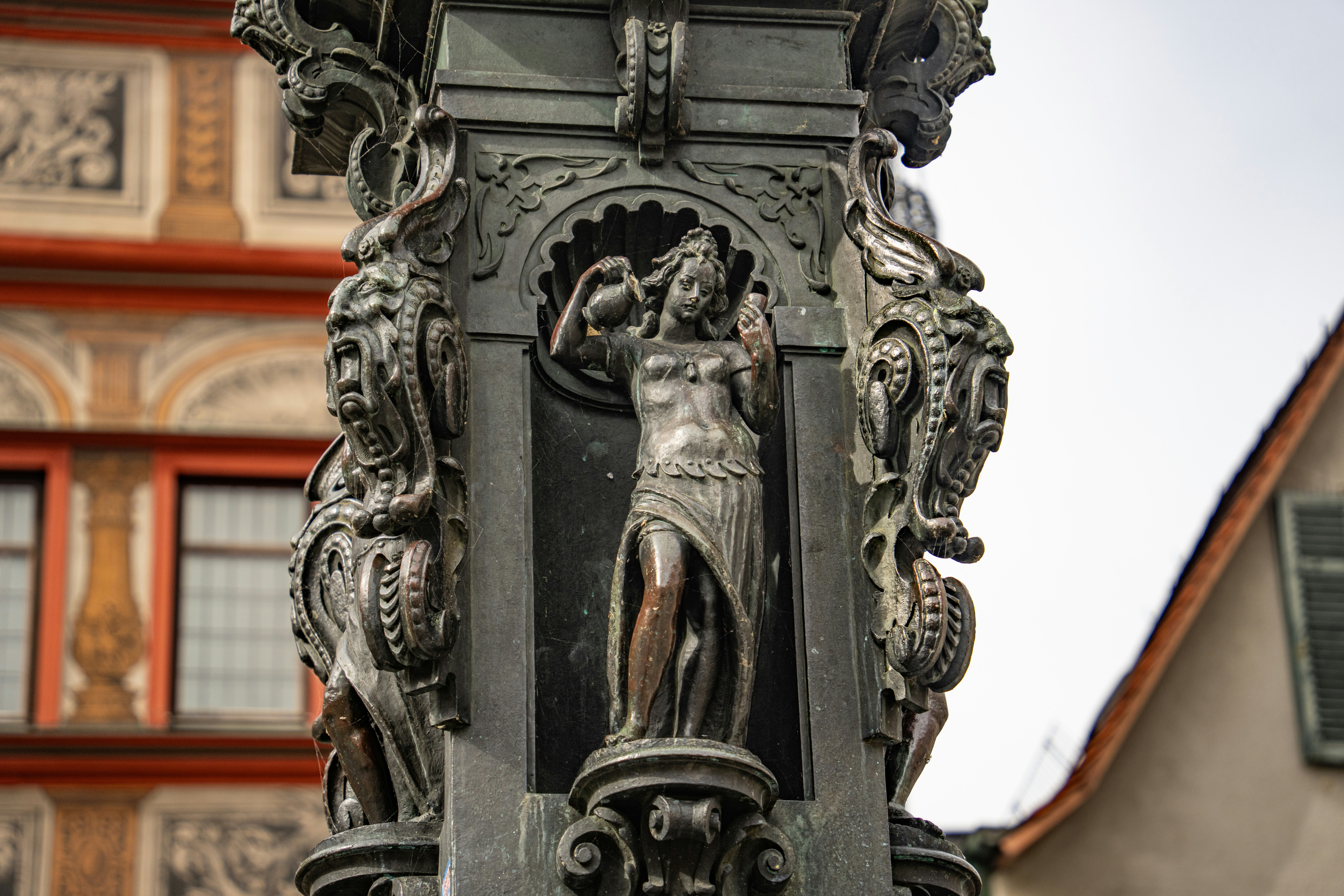 Ornate fountain sculpture of a woman with jug.