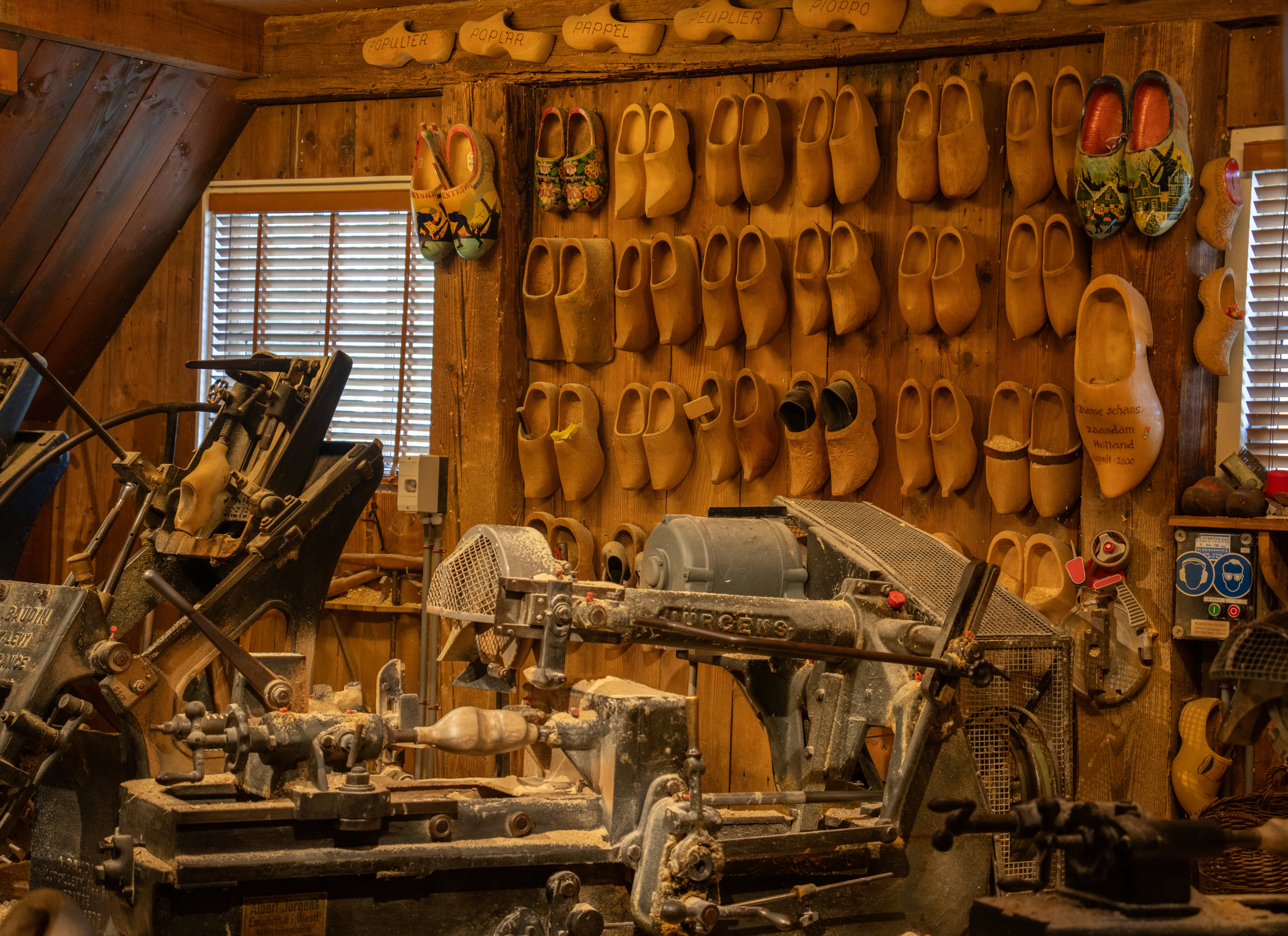Wooden clogs displayed in a workshop with machinery