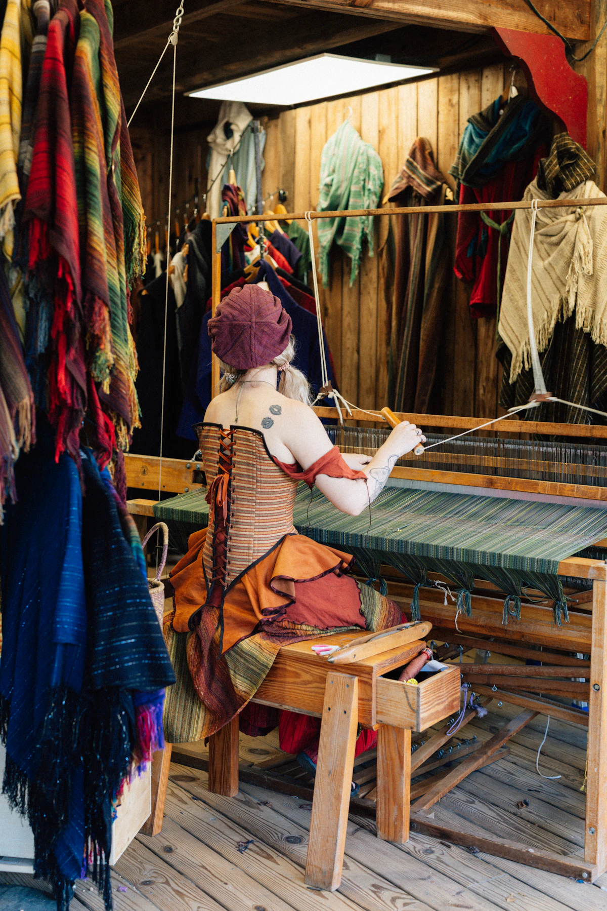 Créatrice tissant du textile sur un métier à tisser dans son atelier