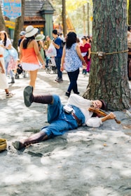 Man in costume plays violin lying on the ground.