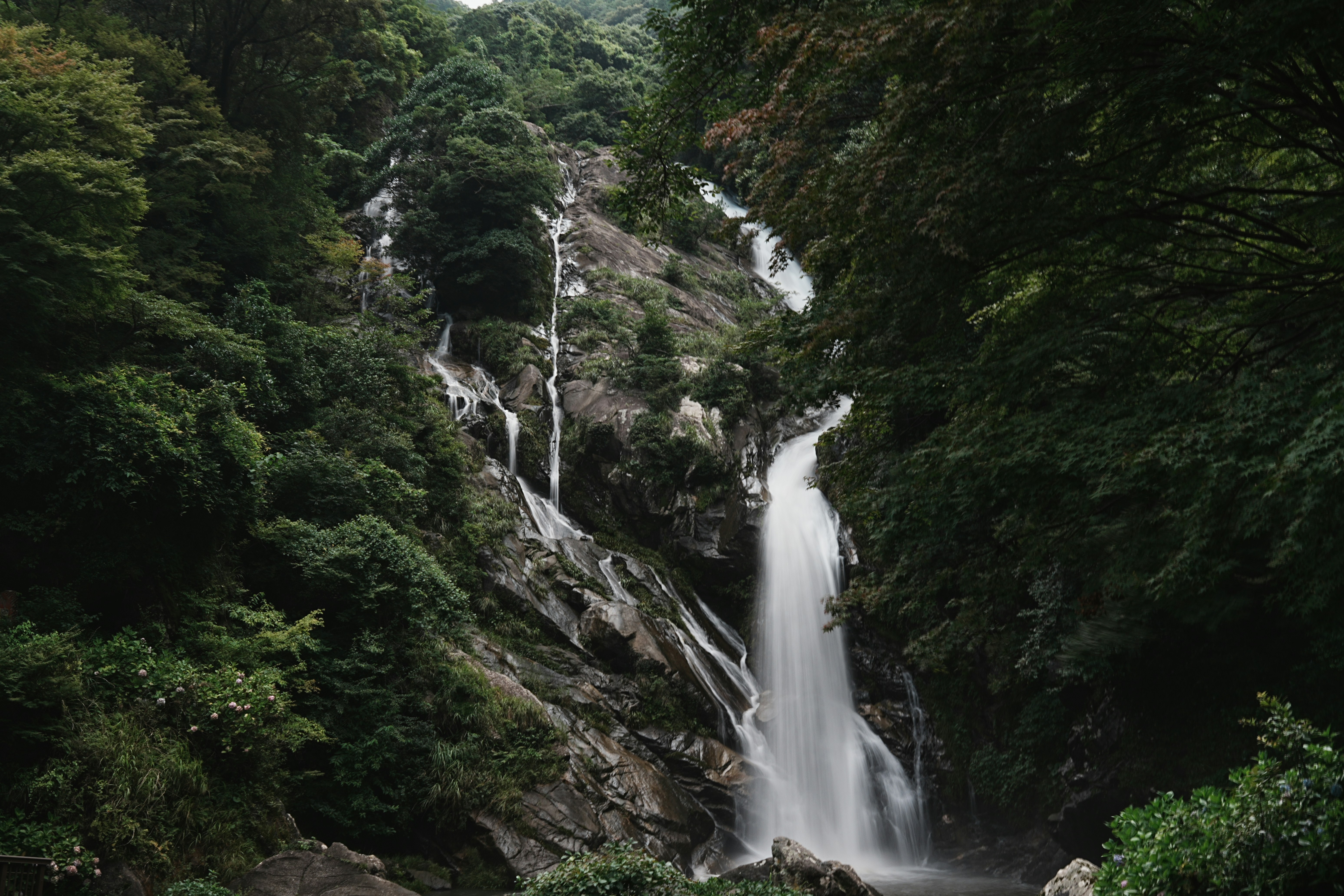 Tall waterfall cascading down rocky mountainside