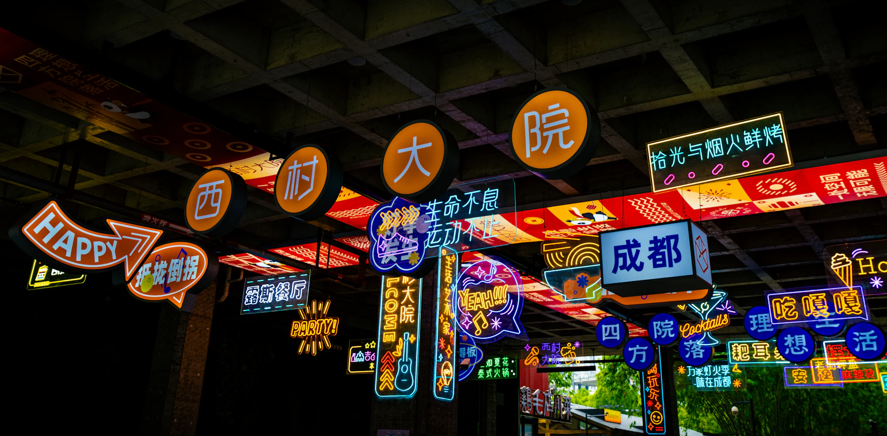 A covered street at night hung with dozens of glowing neon shop signs in Chinese characters