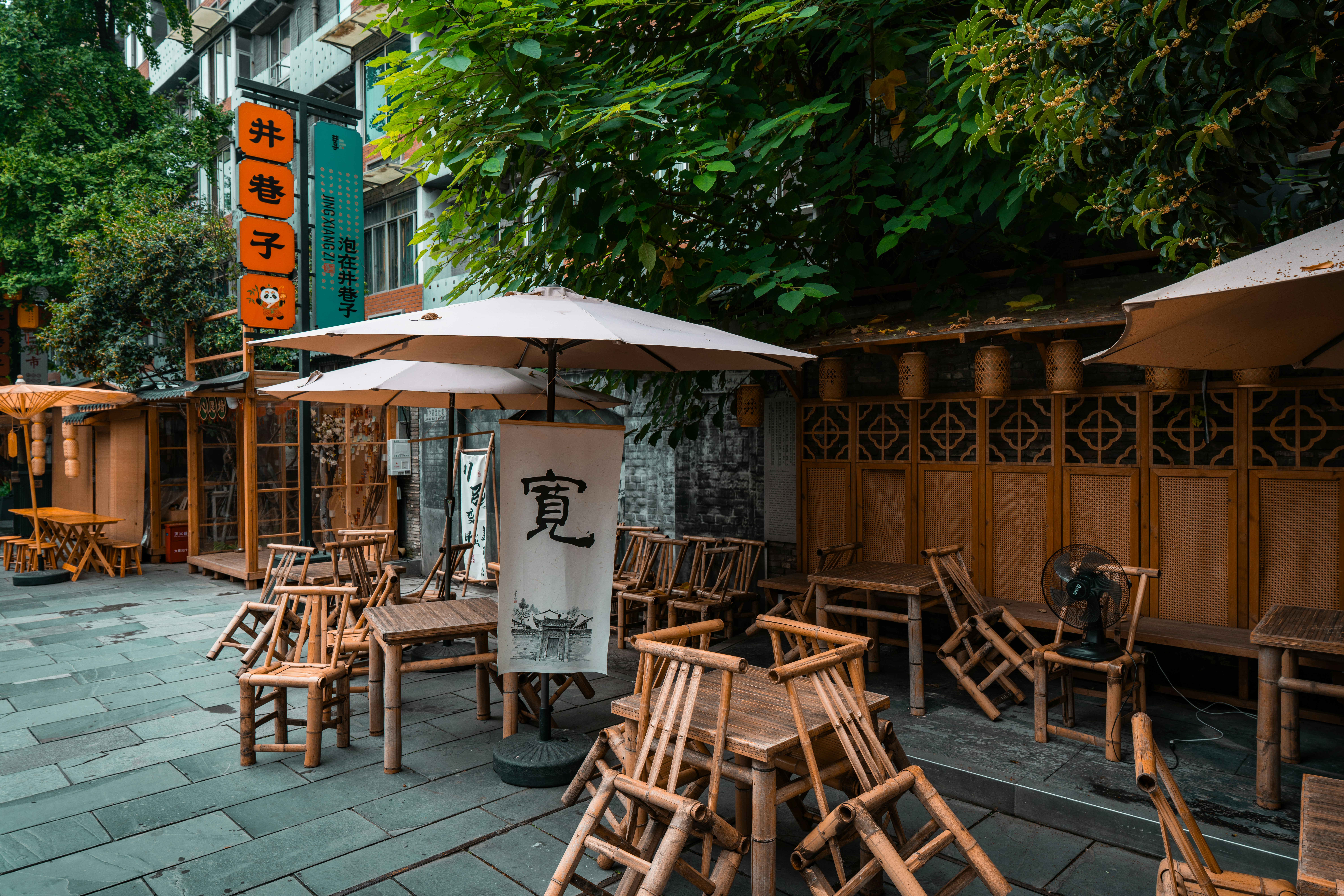Outdoor cafe seating with wooden chairs and tables.