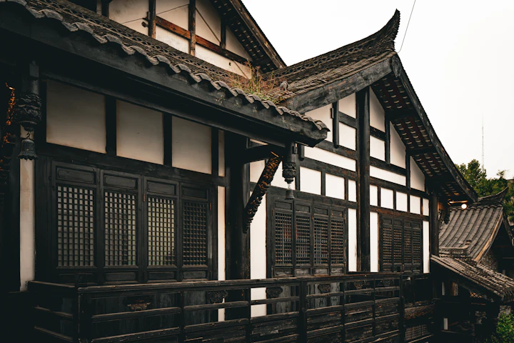 濃い木と白壁の伝統的な日本建築 — 縁側から