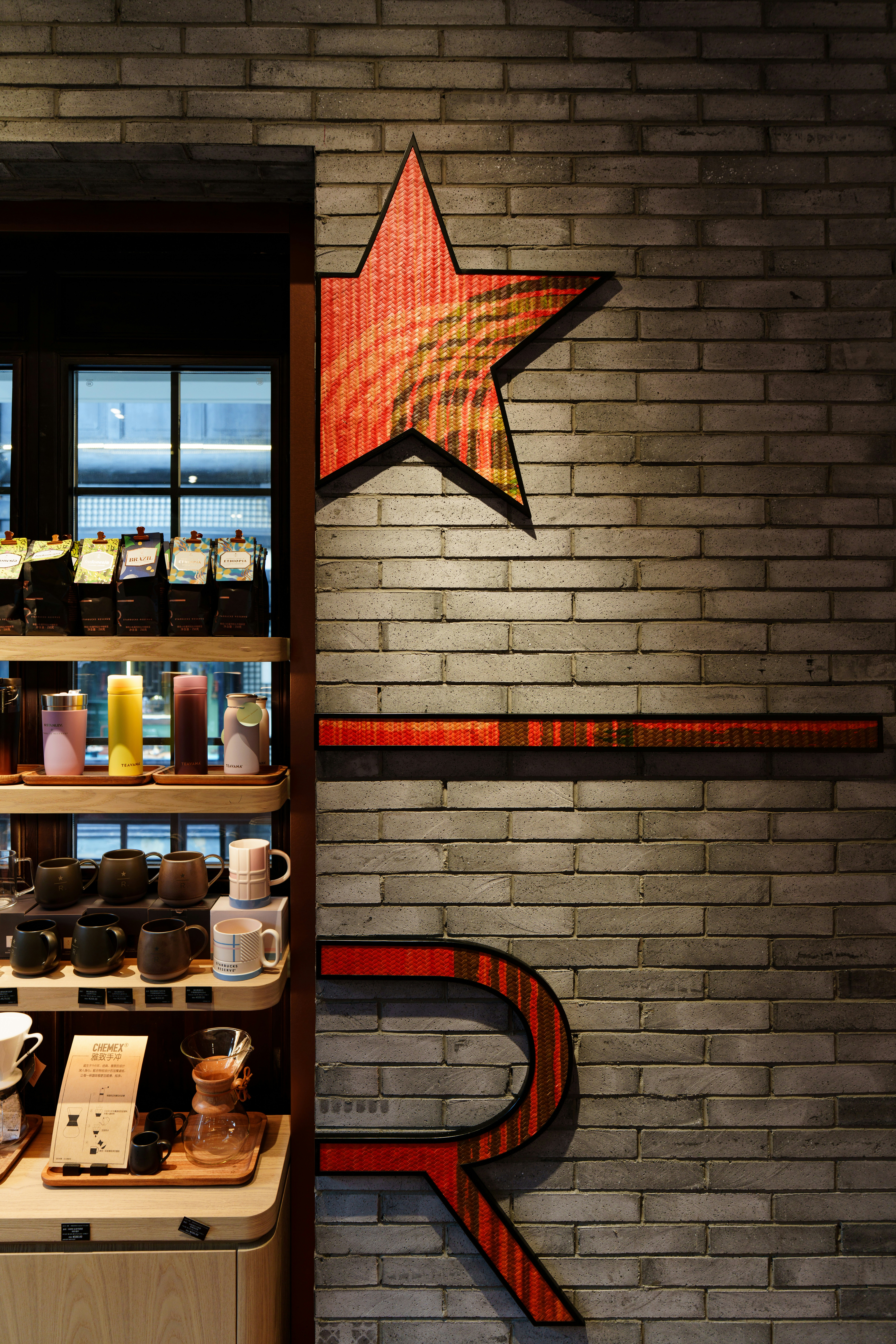 Logotipo de la reserva de Starbucks en la pared de ladrillos con exhibición de mercancía