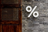 White percentage sign on a brick wall