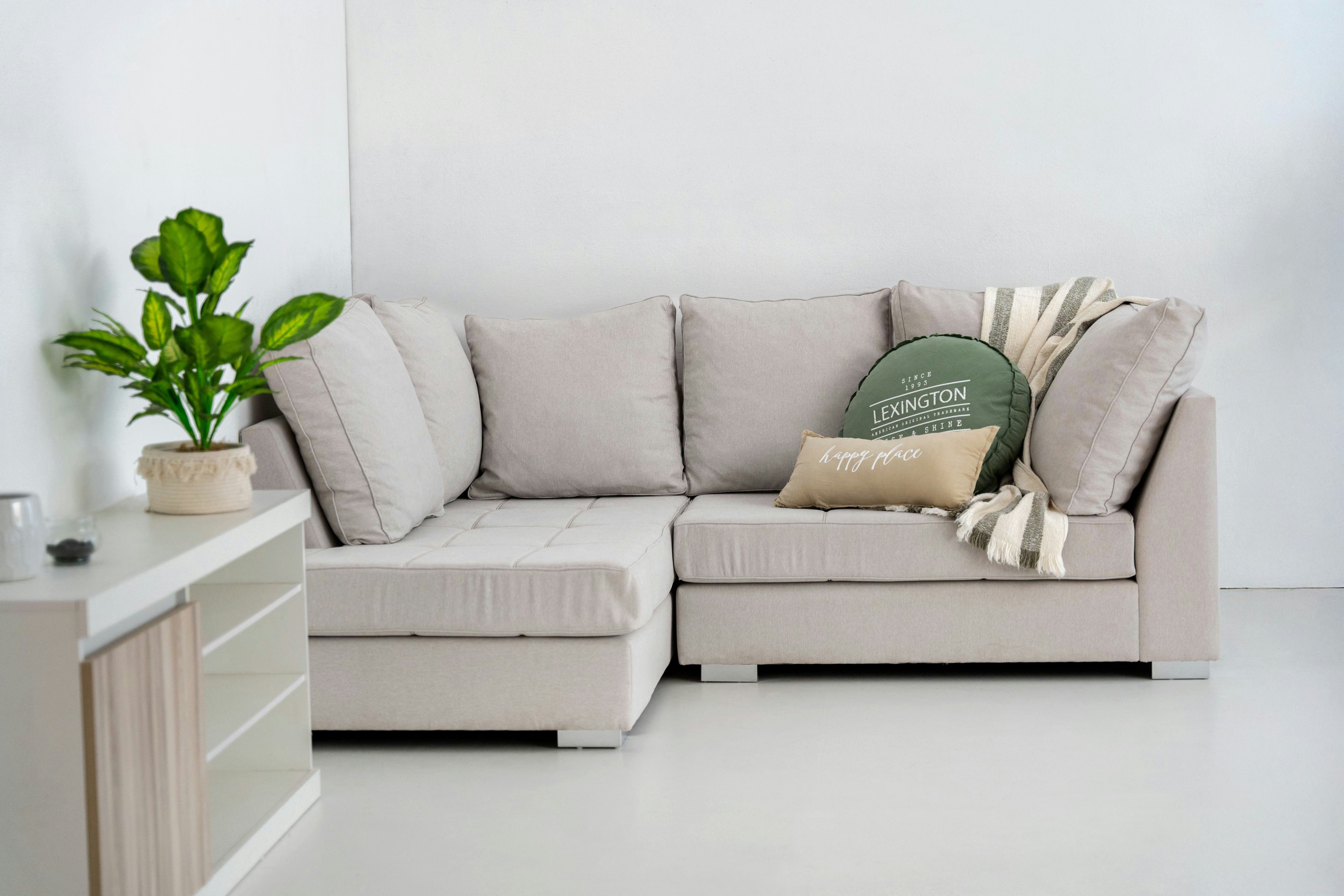 A modern sectional sofa with decorative pillows and throw.