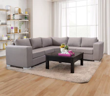 A grey sectional sofa with a dark coffee table.