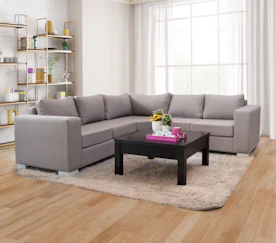 A grey sectional sofa with a dark coffee table.