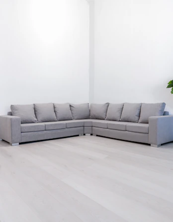 A modern gray sectional sofa in a minimalist room.