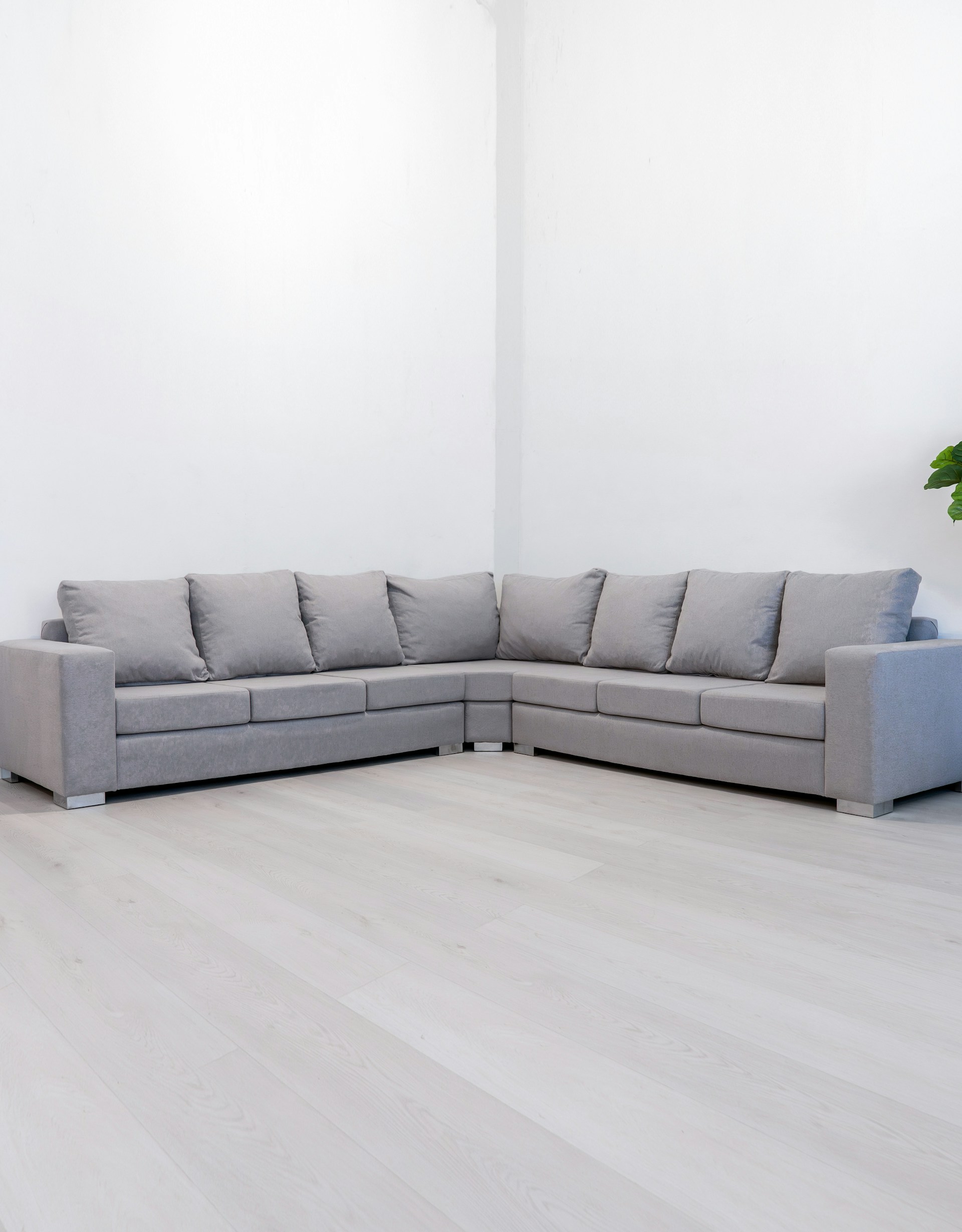 A modern gray sectional sofa in a minimalist room.