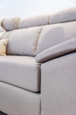 A close-up of a light grey fabric sofa.