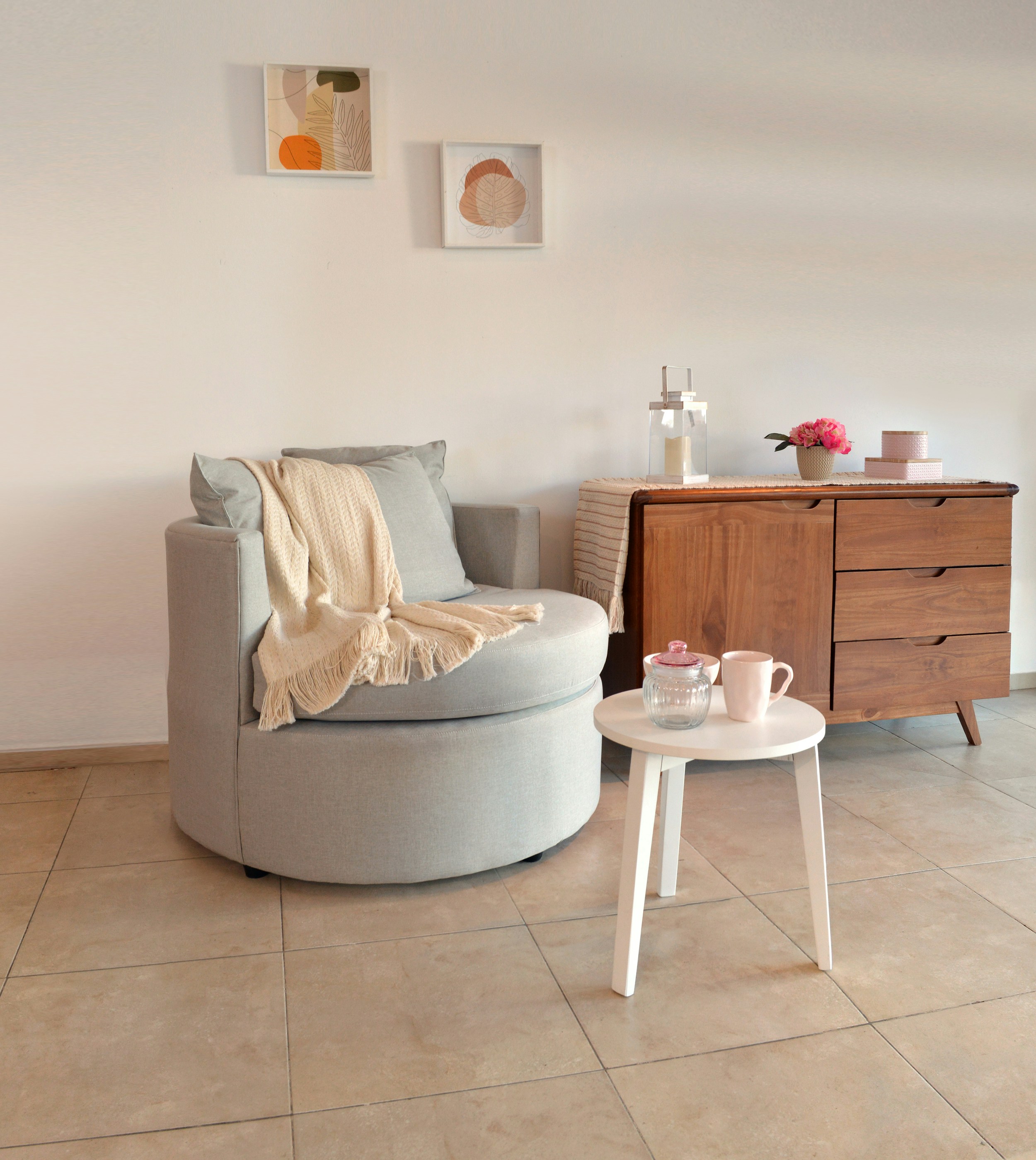 A cozy armchair with a blanket and side table.