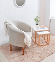 Cozy armchair with throw blanket next to side tables.