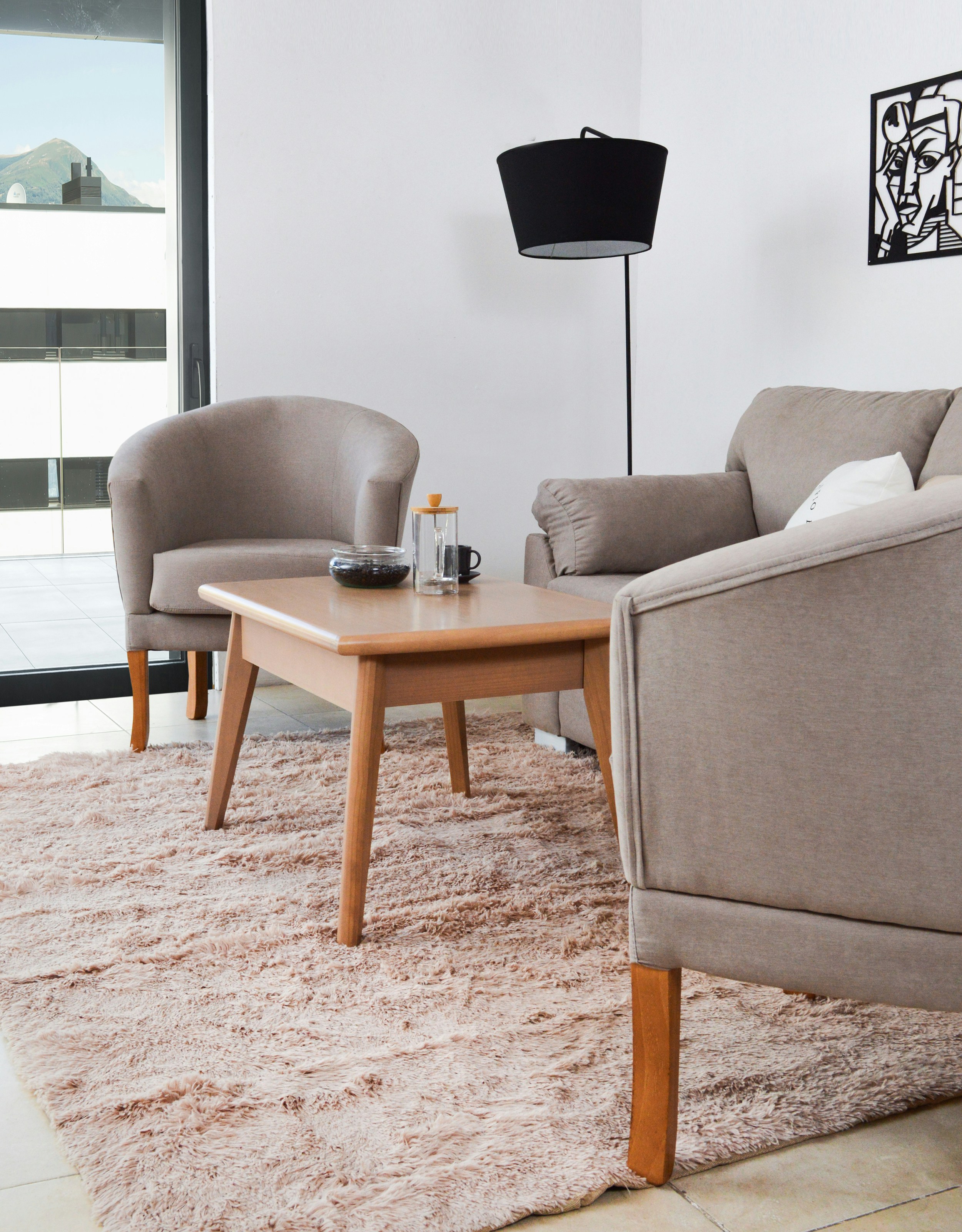 Modern living room with beige chairs and coffee table.